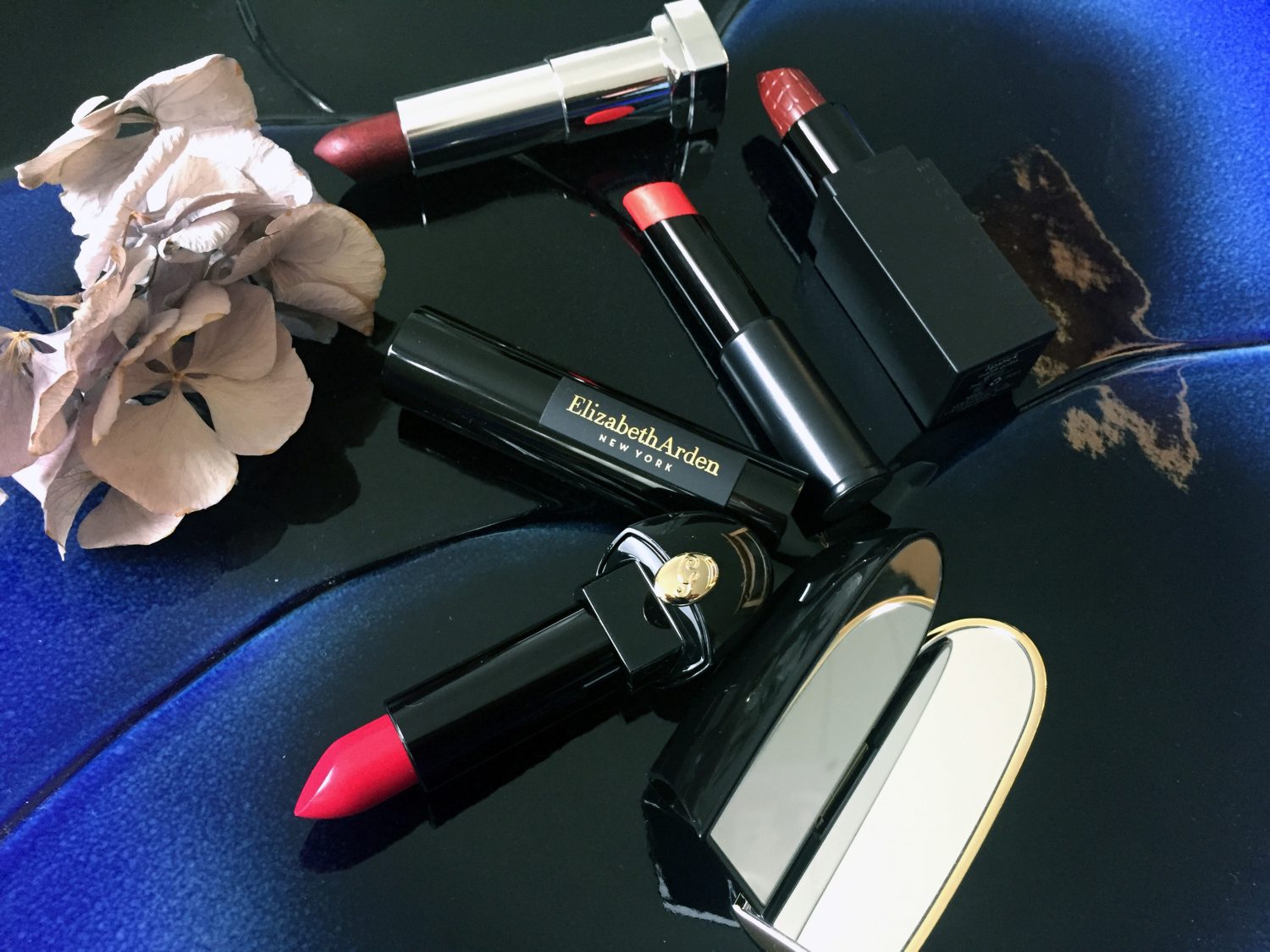 Ylhäällä Maybelline sävy 25 Copper Rose Metallic, keskellä Ellizabeth Arden Plush Up Lip Celato sävy Cherry Up! 17, Make Uo Store sävy Mardi Gras Glossy ja alhaalla Guerlain Rouge À Levres sävy 822 Glamorous Cherry.